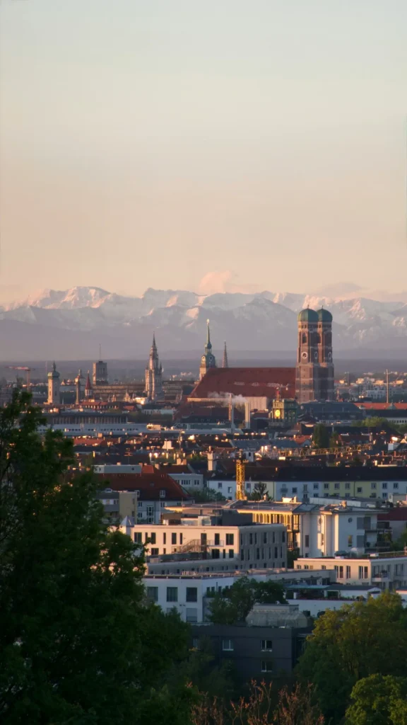 München Skyline mit Frauenkirche und Alpen — KLAR Partners Büro im Herzen des Mittelstands